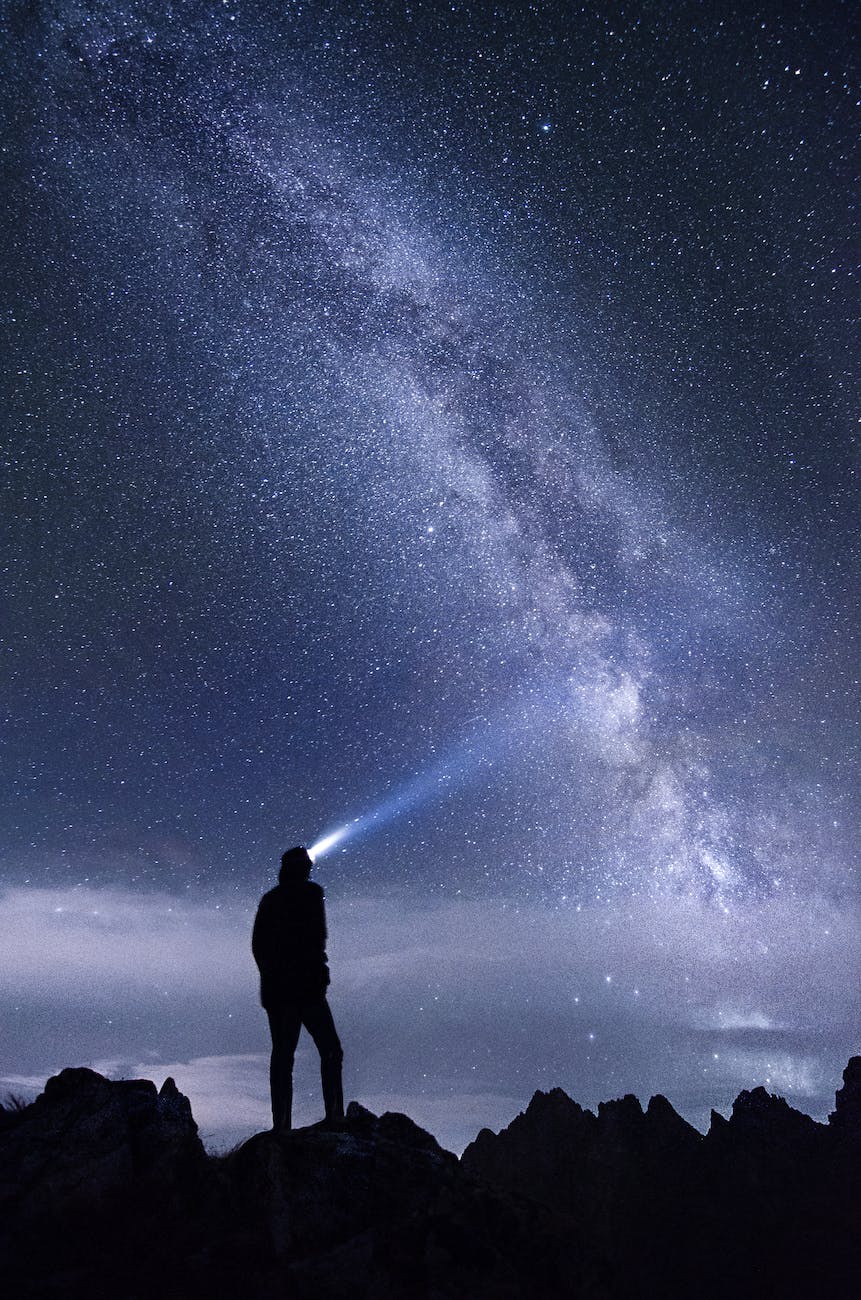 silhouette of man standing on mountain during night
